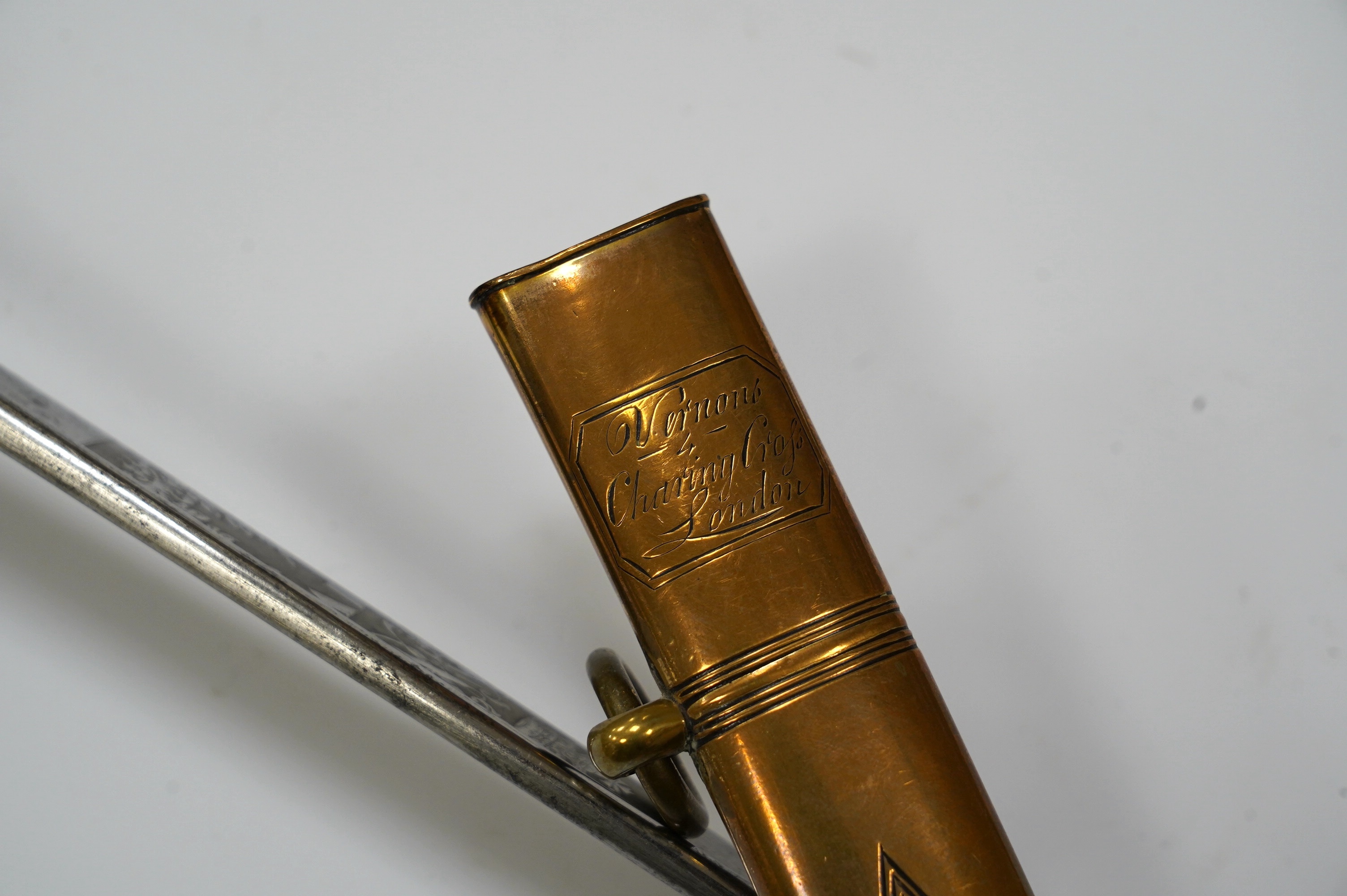 An early 19th century officer's sword, William IV cypher to knuckle guard, folding knuckle guard, engraved curved blade with William IV cypher and makers signature; ‘Vernon 4 Charing Cross London’, leather scabbard with